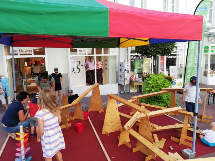 Die große Murmelbahn von Spiel-o-Top unter dem bunten Faltzelt ist ein großer Spaß für Kinder.